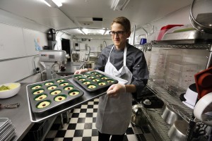 Chef Alex Tretter carries a tray of  cannabis-infused peanut butter and jelly cups to the oven for baking, at Sweet Grass Kitchen, a well-established gourmet marijuana edibles bakery which sells its confections to retail outlets, in Denver.   (AP Photo/Brennan Linsley)