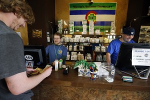 A customer pays cash for retail marijuana at 3D Cannabis Center, in Denver, Colorado, one of two states where recreational marijuana is now legal. Many states are watching to see how much tax revenue legalized marijuana brings in – so far in Colorado, sales have been far under projections, although they continue to grow. (AP)