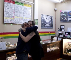 Medical marijuana card holder Ross Montana embraces dispensary owner Aligra Rainy inside the dispensary at Collective Awakenings on Sept. 11, 2014 in Portland, Ore. Collective Awakenings, is among the more well-known medical marijuana retailers in the state and bustles with patients. Co-owner Alex Pavich isn't sure whether he'll vote for Initiative 91. The measure on November's ballot would open the door to recreational marijuana in Oregon and make the state one of only three in the U.S. to allow anyone over 21 to possess pot. Pavich, a medical marijuana grower, worries recreational pot will shift the focus from patients to profit. (AP Photo/The Oregonian, Beth Nakamura) 