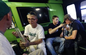 Employees of marijuana tour operator Maryjane Entertainment give out free samples of concentrated pot called "dabs," inside one of their tour buses, in Denver.  (AP Photo/Brennan Linsley)
