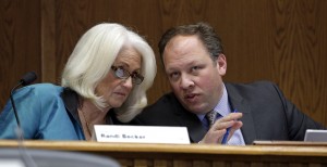 State Sens. Randi Becker, left, R-Eatonville, and David Frockt, D-Seattle, talk with each other during a senate hearing on the Cannabis Patient Protection Act, Thursday, Jan. 22, 2015, in Olympia, Wash. Hundreds of medical marijuana patients were expected in Olympia on Thursday as lawmakers held their first major hearing on how to reconcile the unregulated system with legal recreational pot sales. (AP Photo/Elaine Thompson)