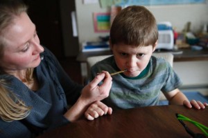 n this Jan. 1, 2015, photo, Nicole Gross uses an oral syringe to give her son Chase his daily dose of a medical marijuana oil, known as Charlotte's Web, at their home in Colorado Springs, Colo. They moved to Colorado from Chicago about a year ago to legally treat Chase, who used to have hundreds of seizures per day. (AP Photo/Brennan Linsley) 