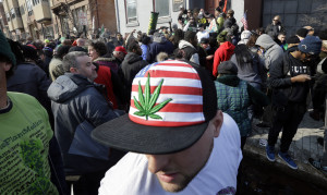 A man wears a hat with a marijuana depiction as a large group gathered near the New Jersey Statehouse to show their support for legalizing marijuana Saturday, March 21, 2015, in Trenton, N.J. The event was led by Ed Forchion, a pro-marijuana activist known as NJ Weedman. He renewed his calls for lawmakers to legalize the drug, saying it should be treated like alcohol. (AP Photo/Mel Evans)