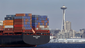 In this Feb. 15, 2015 file photo, the Space Needle towers in the background beyond a container ship anchored in Elliott Bay near downtown Seattle.   (AP Photo/Elaine Thompson)