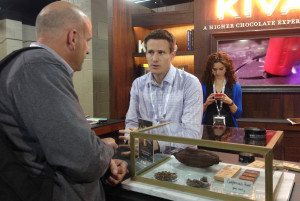 Kiva Confections CEO Scott Palmer, center, talks to a potential client at a marijuana trade show at the Marijuana Business Conference & Expo in Chicago.  The California company makes premium chocolates infused with cannabis. (AP Photo/Carla K. Johnson)