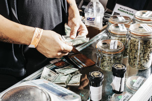 A customer pays for his marijuana purchase at one of Bruce Nassau's five shops in Denver, April 19, 2015. The country's rapidly growing marijuana industry is forced to pay crippling federal income taxes because of a decades-old law aimed at preventing drug dealers from claiming their smuggling costs and couriers as business expenses on their tax returns. (Benjamin Rasmussen/The New York Times)