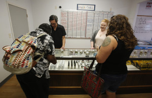  Canna Care employees John Hough, second from left and Jill Van Winkle, third from left, help customers at the medical marijuana dispensary in Sacramento, Calif. A pair of bills pending in the California Legislature would create the first statewide regulations for medical marijuana growers, manufacturers of pot-infused products, and distributors such as storefront dispensaries and delivery services. (AP Photo/Rich Pedroncelli)