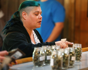 Melody Thomas, of Salem, places an order at CannaMedicine, Thursday, Oct. 1, 2015, in Salem, Ore. Oregon marijuana shops began selling marijuana Thursday for the first time to recreational users, marking a big day for the budding pot industry. (Brent Drinkut/Statesman-Journal via AP)
